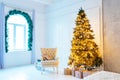 Christmas living room with a Christmas tree, sofa, gifts and a large window. Beautiful New Year decorated classic home interior Royalty Free Stock Photo