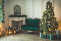 Christmas living room with a fireplace, sofa, Christmas tree and gifts. Beautiful New Year decorated classic home interior. Winter Royalty Free Stock Photo