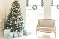 Christmas living room with a fireplace, sofa, Christmas tree, gifts and a large window. Beautiful New Year decorated classic Royalty Free Stock Photo