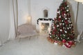 Christmas living room with a fireplace, sofa, Christmas tree and gifts. Beautiful New Year decorated classic home interior. Royalty Free Stock Photo