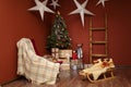 Christmas living room interior with fir-tree armchair, decorative stars and sleigh. Winter holidays Royalty Free Stock Photo