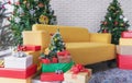 Christmas living room, Yellow sofa with Christmas trees, gift boxes, and Christmas decorations Royalty Free Stock Photo