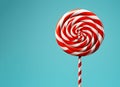 Christmas lollipop isolated over light blue background, copy space. New year candy icon with spiral red and white stripes and Royalty Free Stock Photo