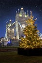 Christmas in London: a beautiful decorated tree in front of the illuminated Tower Bridge