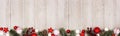 Christmas long border banner with red and white ornaments and branches, top view on a gray wood background Royalty Free Stock Photo