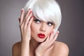 Christmas makeup and manicure nails. Surprised woman face posrtrait. blonde girl with short bob white hair style and red lips Royalty Free Stock Photo