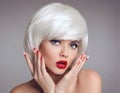 Christmas makeup and manicure nails. Surprised woman face posrtrait. blonde girl with short bob white hair style and red lips Royalty Free Stock Photo