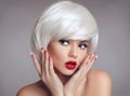 Christmas makeup and manicure nails. Surprised woman face posrtrait. blonde girl with short bob white hair style and red lips Royalty Free Stock Photo