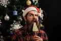 Christmas man with beard on surprised face and lollipop.