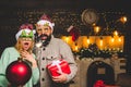 Christmas man hold bomb. Christmas sale. Happy couple in Santa hat at Xmas family party. New year party in home. Royalty Free Stock Photo