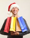 Christmas man. Man holding shopping bags. Christmas sales. Man wearing Santa claus hat in shopping time. New year holidays. Christ Royalty Free Stock Photo