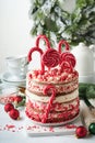 Christmas many layers cake decorated with lolli pops, red and white confetti on white cake stand, Christmas balls, fir branches on