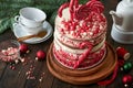 Christmas many layers cake decorated with lolli pops, red and white confetti on white cake stand, Christmas balls, fir branches on