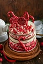 Christmas many layers cake decorated with lolli pops, red and white confetti on white cake stand, Christmas balls, fir branches on Royalty Free Stock Photo