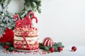 Christmas many layers cake decorated with lolli pops, red and white confetti on white cake stand, Christmas balls, fir branches on Royalty Free Stock Photo