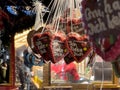 Christmas market in the evening in city. Gingerbread hearts with German text: I love you.