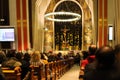 Christmas mass in the Catholic cathedral, people are sitting on the benches, near the altar, the Christmas choir performs