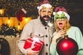 Christmas man hold bomb. Christmas sale. Happy couple in Santa hat at Xmas family party. New year party in home. Royalty Free Stock Photo