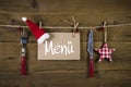 Christmas menu card for restaurants with knife and fork on wooden background.