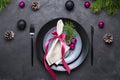 Christmas menu concept . Flat lay with Xmas decorations, dark plates, fork and knife with napkin Royalty Free Stock Photo