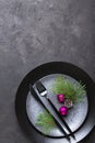 Christmas menu concept . Flat lay with Xmas decorations, dark plates, fork and knife set with napkin. Royalty Free Stock Photo