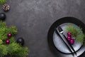 Christmas menu concept . Flat lay with Xmas decorations, dark plates, fork and knife set with napkin. Royalty Free Stock Photo