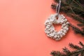 Christmas meringue wreath on the fir branch on the living coral color background. Color of the year 2019 Living Coral