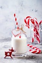 Christmas milk for Santa in bottle with straw and peppermint candy cane. Christmas holiday party drink
