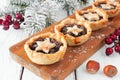 Christmas mincemeat tarts on a serving board. Table scene on white wood. Royalty Free Stock Photo