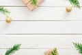 Christmas minimal composition. Christmas frame made of fir tree branches, golden decorations, wrapped gifts on white wooden desk. Royalty Free Stock Photo