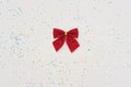 Christmas minimal composition. Red bow isolated on white background with glitter. New Year concept. Copy space Royalty Free Stock Photo