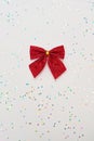 Christmas minimal composition. Red bow isolated on white background with glitter. New Year concept. Copy space Royalty Free Stock Photo