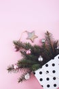 Christmas minimal flat lay composition with fir branches, shiny christmas balls, wooden star  in polka dot gift bag on pastel Royalty Free Stock Photo