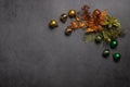 Christmas minimalism composition. New Year`s green and orange decorations in the form of flowers and balls on a dark bac