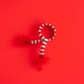 Christmas minimalistic composition. White and red striped scarf decoration on red. Christmas, winter, new year concept