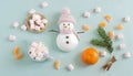 christmas minimalistic flat lay background with a snowman, marshmallows, and tangerines