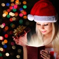 Christmas Miracle. Happy Blonde Girl with Santa Hat Opening Gift Royalty Free Stock Photo