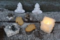 Christmas mitten cookies, ball from twig, gift boxes in craft paper and white candle with fire on wooden table with snow