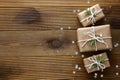 Christmas mock up with gift boxes wrapped with brown kraft paper over wooden board