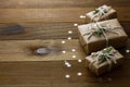 Christmas mock up with gift boxes wrapped with brown kraft paper over wooden board