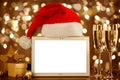 Christmas mockup. Blank tablet and Santa hat on blurred background of winter holiday Royalty Free Stock Photo