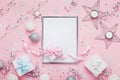Christmas mockup with frame, holiday balls, gift boxes and sequins on stylish pink table top view. Fashion festive background. Royalty Free Stock Photo