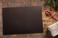 Christmas mockup. Christmas greeting card or photo frame over wooden table with black blank paper Royalty Free Stock Photo