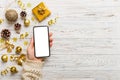 christmas mockup with space for text. christmas advertising, app template. hand holding phone with empty screen on table Royalty Free Stock Photo