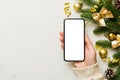 christmas mockup with space for text. christmas advertising, app template. hand holding phone with empty screen on table Royalty Free Stock Photo