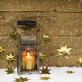 Christmas mood: old rustic latern on a snowy background.