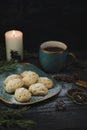 Christmas mood, pastries with coffee and spices, candle and juniper sprigs on an old wooden brown table Royalty Free Stock Photo