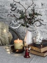 Christmas mood still life. Burning candle,stack of books, christmas tree, garland, knitting plaid on the table Royalty Free Stock Photo