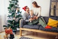 Family gathered around a Christmas tree, using a tablet Royalty Free Stock Photo