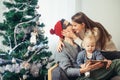 Family gathered around a Christmas tree, using a tablet Royalty Free Stock Photo